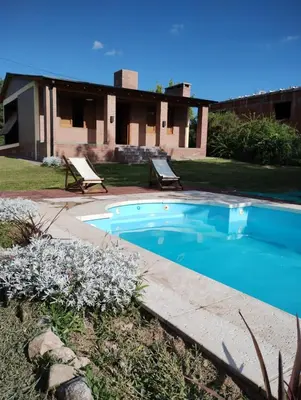 a swimming pool in front of a house at Alberobello Casa Serrana in Santa Rosa de Calamuchita