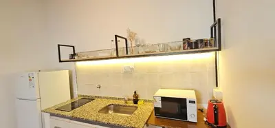 a kitchen with a counter with a sink and a refrigerator at LitStay Monoambiente in Cordoba