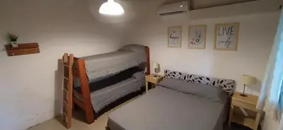 a room with two bunk beds and a couch at Departamento San Antonio in San Antonio de Arredondo