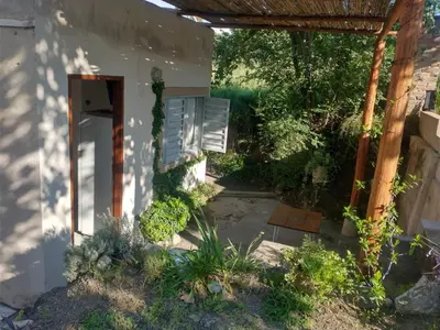 a garden with a building with a pergola at Departamento San Antonio in San Antonio de Arredondo