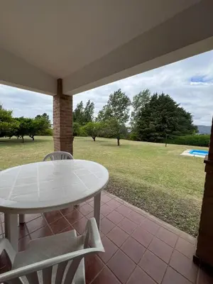 a table and chairs on a porch with a view of a field at Casa en Potrero de Garay in Potrero de Garay
