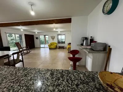 a kitchen and living room with a counter and a table at El Sauce in La Cumbrecita