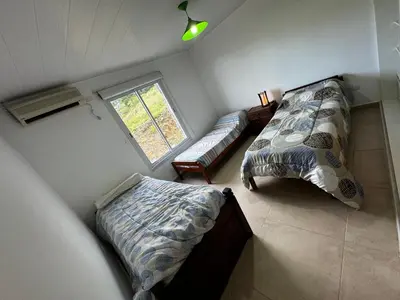 a bedroom with two beds and a window at El Sauce in La Cumbrecita