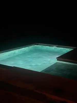 a swimming pool with blue water in the dark at El Sauce in La Cumbrecita