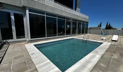 a swimming pool in front of a building at Amérian Río Cuarto in Río Cuarto