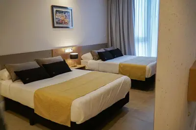 a hotel room with two beds and a window at Amérian Río Cuarto in Río Cuarto