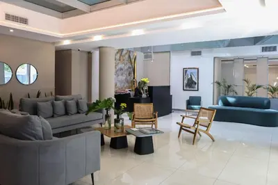 a living room with couches and chairs and a table at Amérian Río Cuarto in Río Cuarto