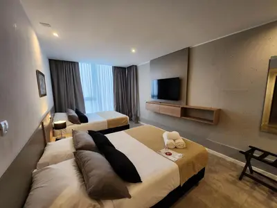 a hotel room with two beds and a flat screen tv at Amérian Río Cuarto in Río Cuarto