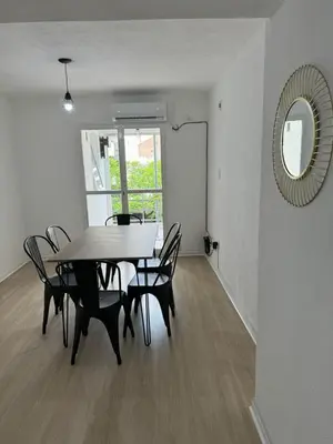 a dining room with a table and chairs and a mirror at Departamento Pleno Centro de Córdoba Capital in Cordoba