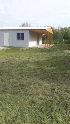 a small white house in a grass field at Casa en Boca del Río in Las Tapias