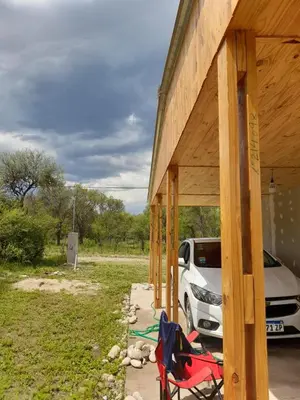 a building with chairs and a car parked next to it at Casa en Boca del Río in Las Tapias