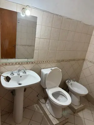 a bathroom with a toilet and a sink at Casa Villa Carlos Paz, con pileta, frente al río in Villa Carlos Paz