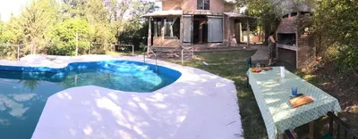 a swimming pool in the yard of a house at Casa Villa Carlos Paz, con pileta, frente al río in Villa Carlos Paz