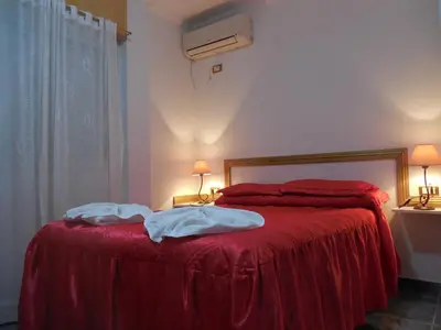 a bedroom with a red bed with two towels on it at Victor Hotel in Villa Carlos Paz