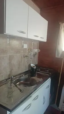 a kitchen counter with a sink and white cabinets at Kapo TEAM , el zorzal in Villa Amancay