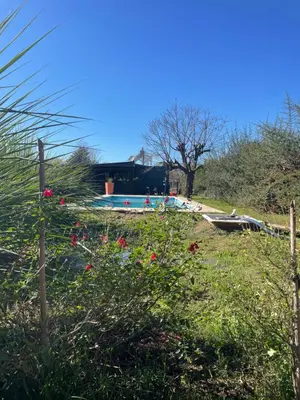 a swimming pool in a yard with flowers and a fence at Kapo TEAM , el zorzal in Villa Amancay