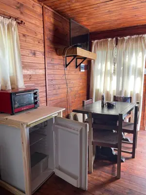 a dining room with a table and a microwave at Kapo TEAM , el zorzal in Villa Amancay