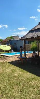 two people sitting at a picnic table next to a pool at Kapo TEAM , el zorzal in Villa Amancay