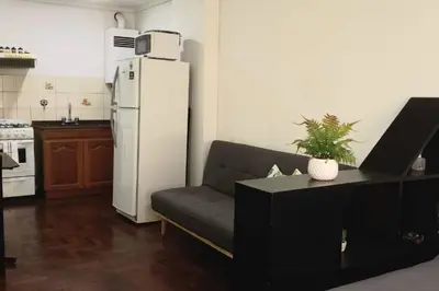 a living room with a couch and a white refrigerator at Monoambiente en Nueva Cordoba in Cordoba