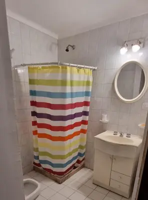 a bathroom with a rainbow shower curtain and a sink at Monoambiente en Nueva Cordoba in Cordoba