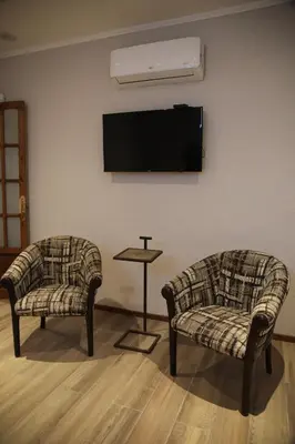 two chairs and a table with a tv on a wall at Village Vistello in Cordoba
