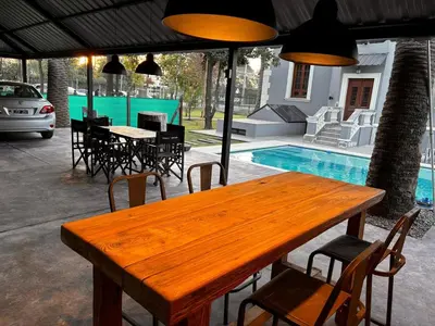 a wooden table and chairs next to a pool at Village Vistello in Cordoba