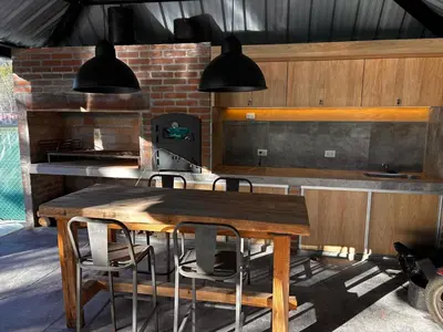 a kitchen with a wooden table and some black lights at Village Vistello in Cordoba