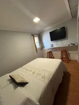 a bedroom with a bed and a flat screen tv at La Casa de Petro in Cordoba