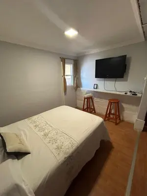 a bedroom with a bed and a flat screen tv at La Casa de Petro in Cordoba
