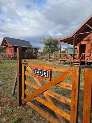 a sign on a wooden fence in front of a building at Cabañas en Los Reartes Córdoba in Villa General Belgrano