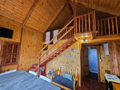 a bedroom with a staircase in a log cabin at Cabañas en Los Reartes Córdoba in Villa General Belgrano