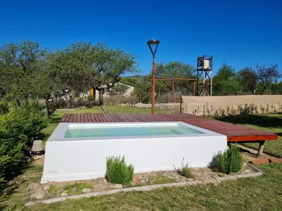 a swimming pool with a bench in a yard at Cabañas en Los Reartes Córdoba in Villa General Belgrano