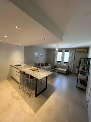 a kitchen and living room with a table and chairs at Departamento equipado in Río Cuarto