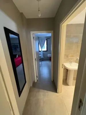 a hallway of a bathroom with a sink and a toilet at Departamento equipado in Río Cuarto
