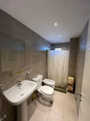 a bathroom with a white toilet and a sink at Departamento equipado in Río Cuarto