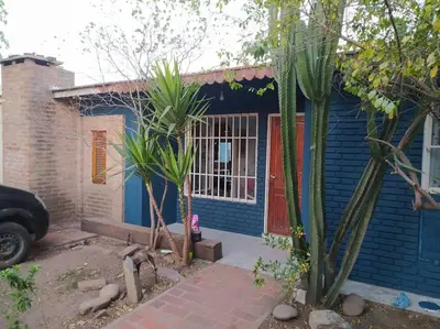 a blue house with a red door and some trees at Colores de arguello in Cordoba
