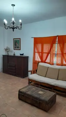 a bedroom with a bed with a ottoman and a table at Casa amplia en las sierras de San Luis in San Francisco del Monte de Oro