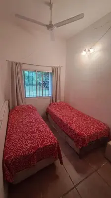a bedroom with two red beds and a window at Casa amplia en las sierras de San Luis in San Francisco del Monte de Oro