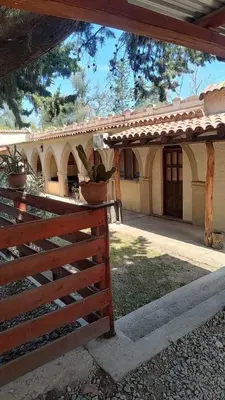 a house with a fence and potted plants on it at Hospedaje FliaMaria in San Javier