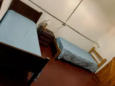a small bedroom with a bed and a dresser at Hospedaje FliaMaria in San Javier