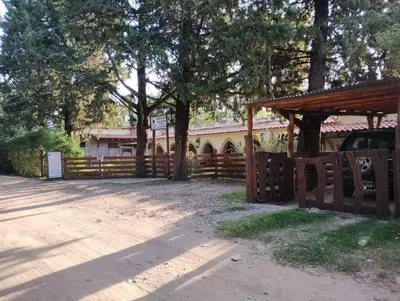 a fence in front of a house with a gate and trees at Hospedaje FliaMaria in San Javier