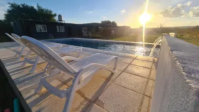 a group of chairs sitting next to a swimming pool at Atardecer Soñado in Villa Cura Brochero