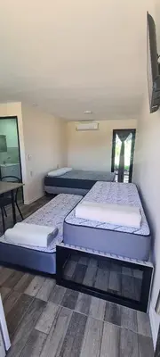 a room with three beds in it with a table at Atardecer Soñado in Villa Cura Brochero