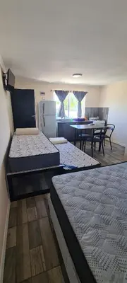 a room with two beds and a dining room with a table at Atardecer Soñado in Villa Cura Brochero