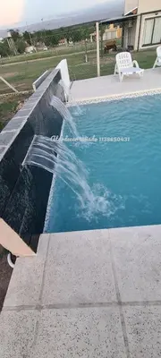 a swimming pool with a water fall in it at Atardecer Soñado in Villa Cura Brochero