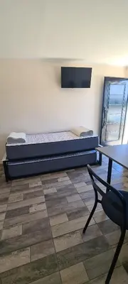 a room with a bed and a table and a chair at Atardecer Soñado in Villa Cura Brochero