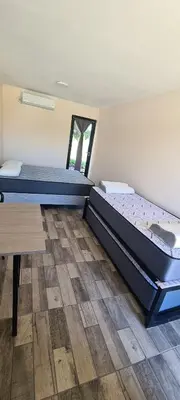 a room with two beds and a wooden floor at Atardecer Soñado in Villa Cura Brochero