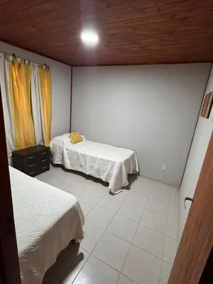 a small room with two beds and a ceiling at Cabañas Adorable Tranquilidad in Cavalango