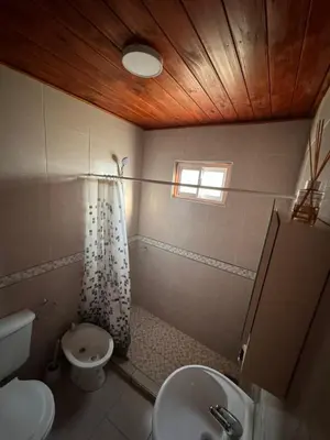 a bathroom with a sink and a toilet and a window at Cabañas Adorable Tranquilidad in Cavalango