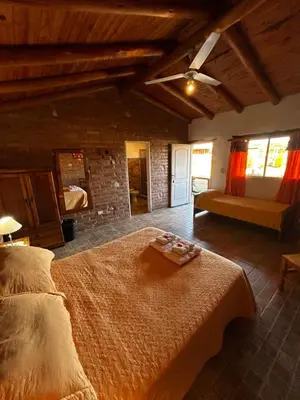a bedroom with a bed and a couch in a room at cabañas Villa de las rosas in Villa de Las Rosas